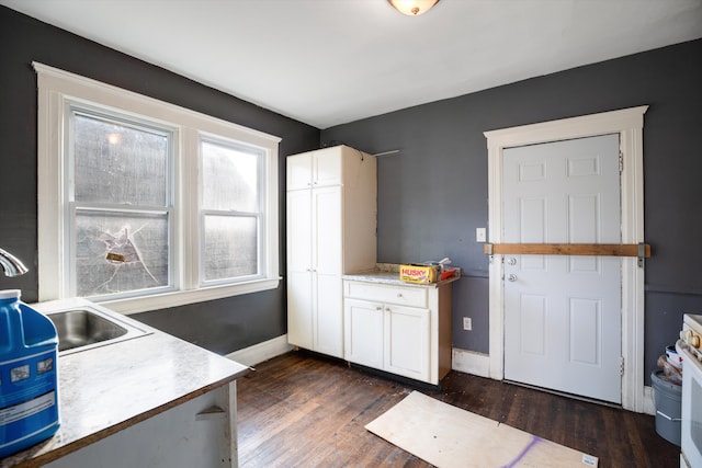 kitchen with dark hardwood / wood-style flooring, white cabinetry, and sink