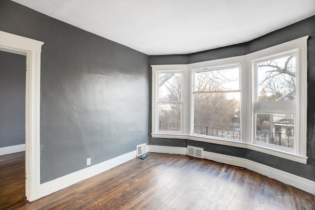 unfurnished room with dark wood-type flooring