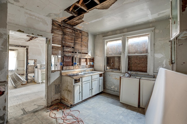 kitchen featuring white cabinets and sink