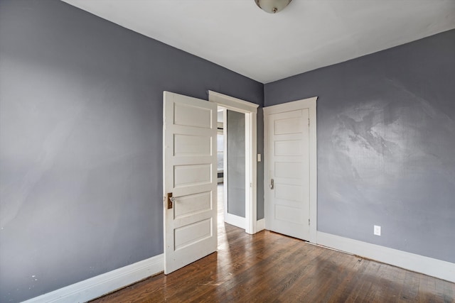 unfurnished room with dark hardwood / wood-style flooring