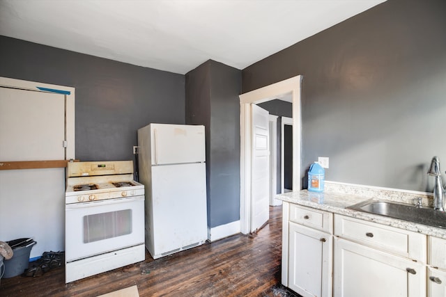 kitchen with white cabinets, dark hardwood / wood-style flooring, white appliances, and sink