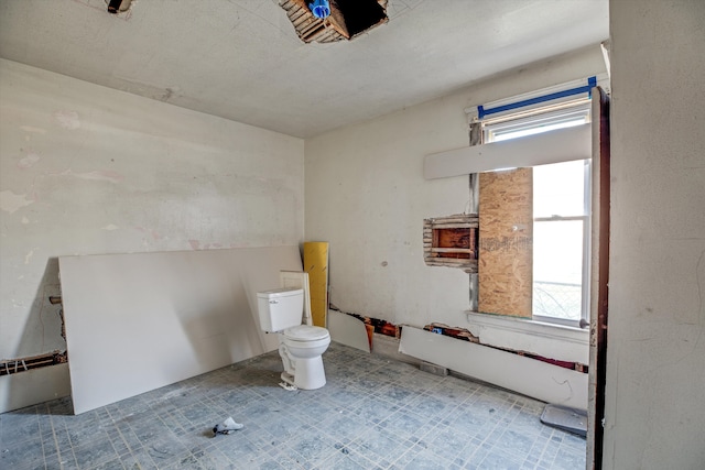 bathroom featuring a wealth of natural light, a baseboard radiator, and toilet