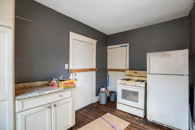 kitchen featuring light stone counters, white appliances, and dark wood-type flooring