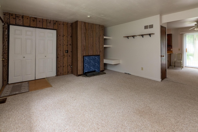 unfurnished living room featuring carpet flooring and ceiling fan