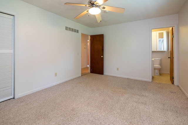 unfurnished bedroom featuring connected bathroom, light carpet, and ceiling fan