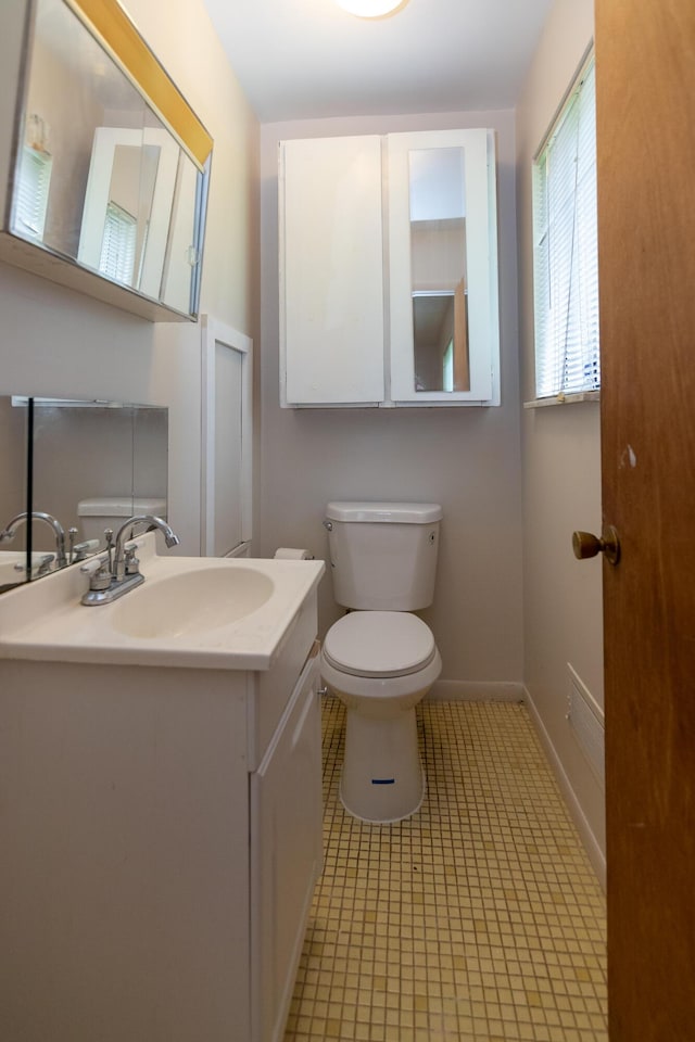 bathroom featuring tile patterned flooring, vanity, and toilet