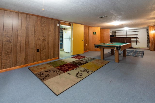 playroom featuring billiards, a textured ceiling, wooden walls, and light carpet