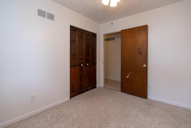 unfurnished bedroom featuring light colored carpet and a closet