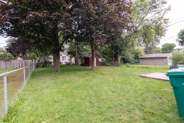 view of yard with a wooden deck and a storage unit