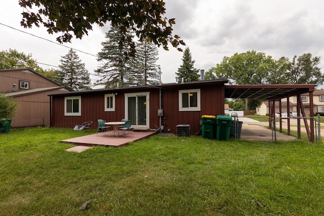 back of property with a carport, cooling unit, and a yard