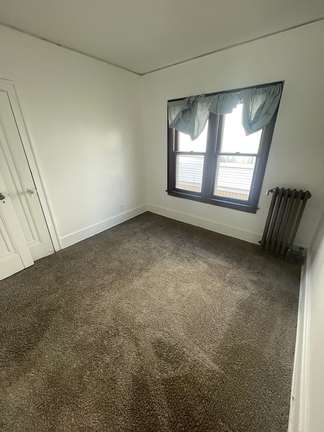 unfurnished room with carpet and radiator