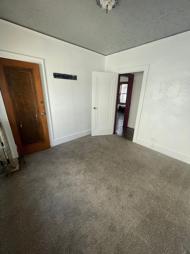 empty room featuring dark colored carpet and a textured ceiling