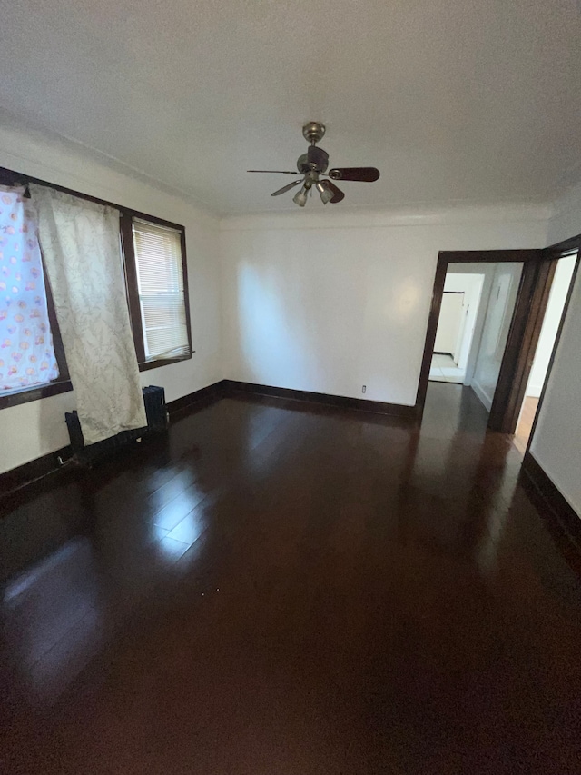 spare room with ceiling fan, dark hardwood / wood-style flooring, and crown molding