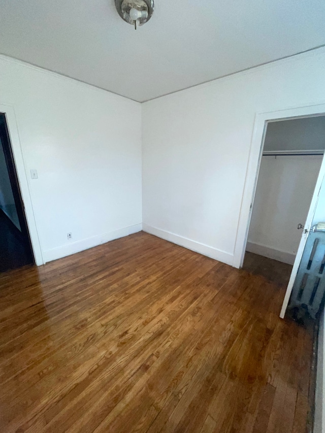 unfurnished bedroom featuring dark hardwood / wood-style flooring and a closet