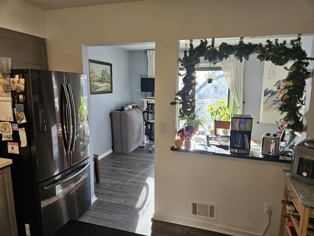 kitchen with stainless steel fridge and dark hardwood / wood-style floors