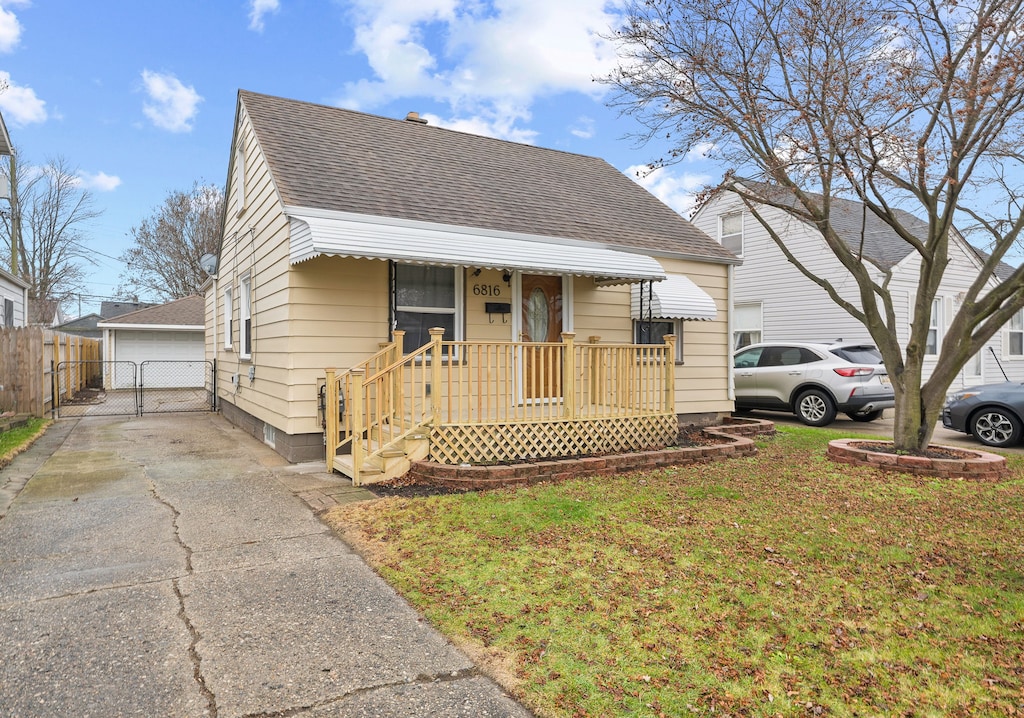 bungalow-style house with a garage, an outbuilding, and a front yard