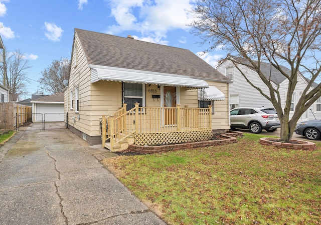 bungalow-style house with a garage, an outbuilding, and a front yard