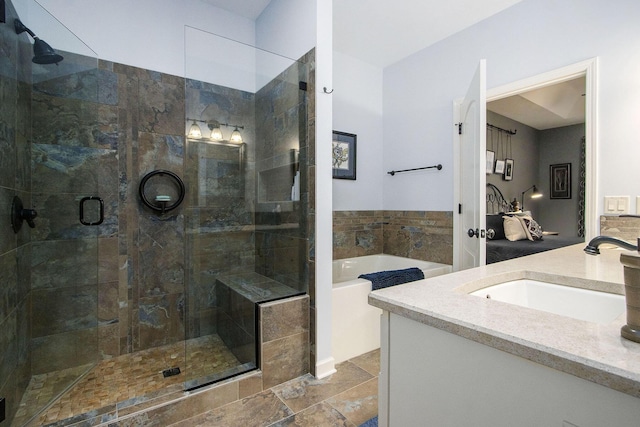 bathroom featuring vanity and independent shower and bath