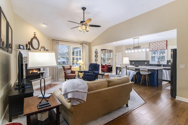 living room with ceiling fan, dark wood-type flooring, and lofted ceiling