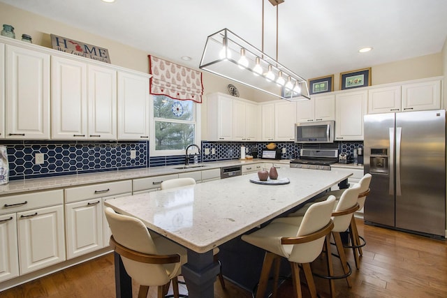 kitchen with pendant lighting, white cabinetry, a center island, and stainless steel appliances