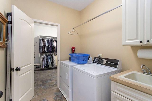 laundry area featuring washing machine and clothes dryer, sink, and cabinets