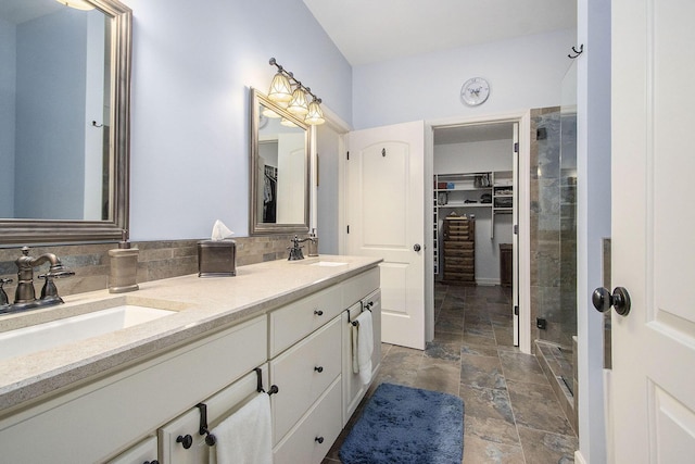 bathroom with tasteful backsplash, a shower with door, and vanity