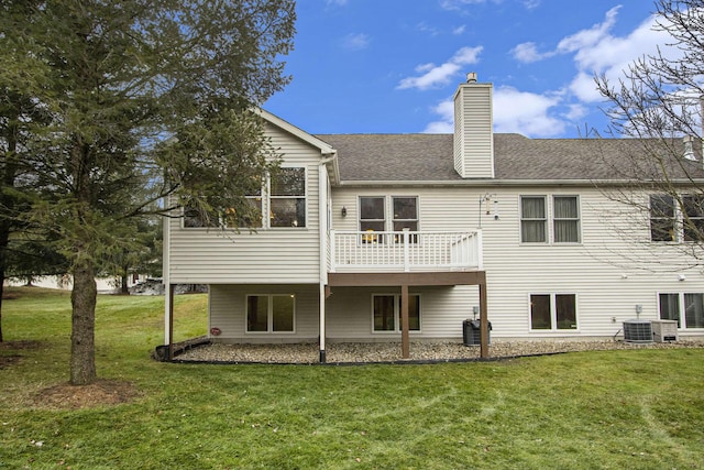 back of house with central AC unit and a yard