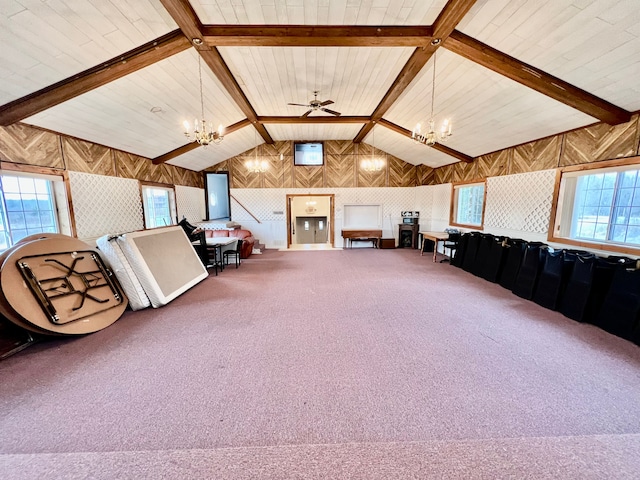 interior space with carpet flooring, ceiling fan with notable chandelier, lofted ceiling with beams, and wooden walls