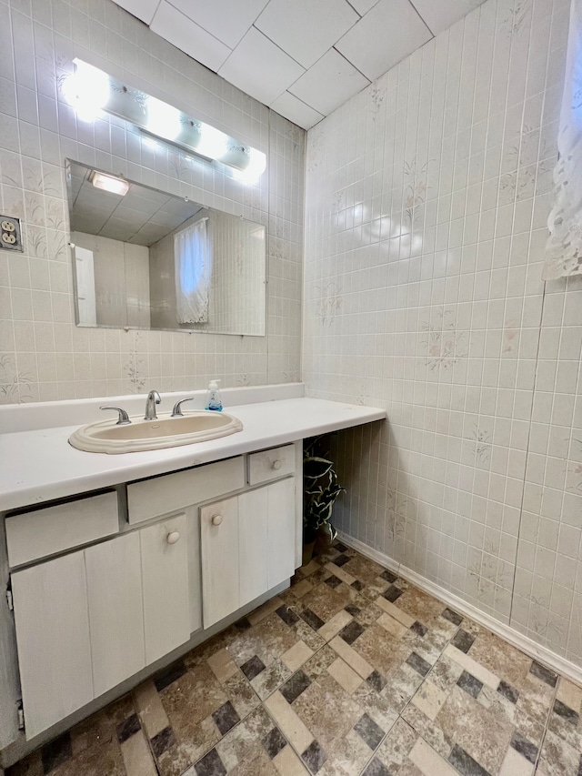 bathroom with vanity and tile walls