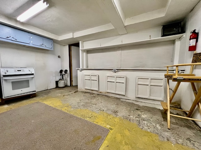 interior space featuring stove, white cabinets, and concrete flooring