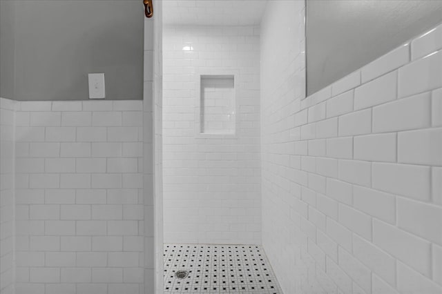 bathroom featuring tile walls and tiled shower