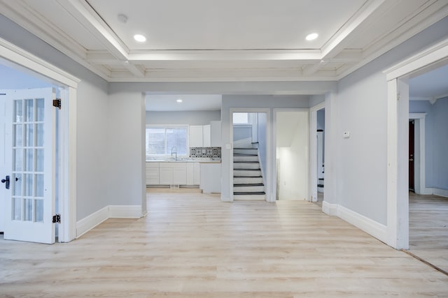 interior space with beam ceiling, light hardwood / wood-style floors, coffered ceiling, and sink