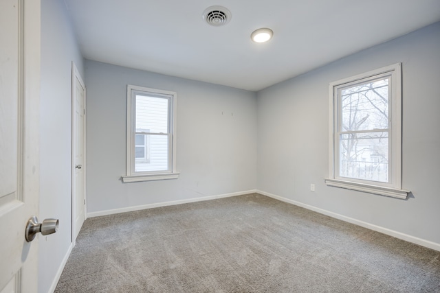 unfurnished room featuring carpet flooring and a healthy amount of sunlight