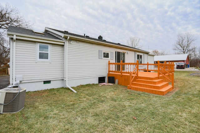 rear view of property featuring cooling unit, a deck, and a yard