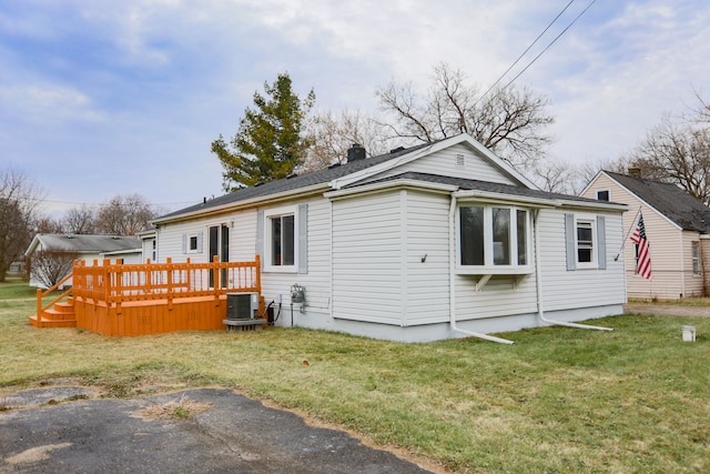 exterior space with a yard, a deck, and central AC unit