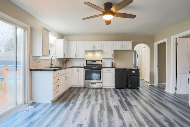 kitchen with backsplash, stainless steel range, ceiling fan, sink, and white cabinets