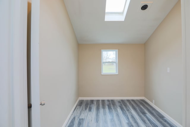 spare room with hardwood / wood-style floors and a skylight