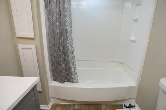 full bathroom with hardwood / wood-style flooring, vanity, toilet, and shower / tub combo