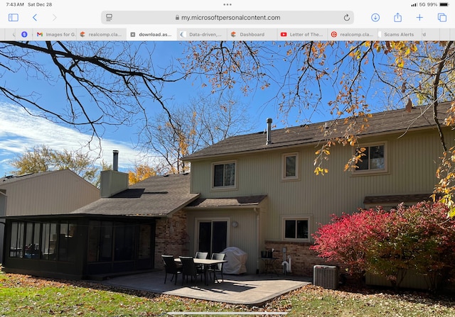 rear view of property with central AC unit, a patio area, and a sunroom