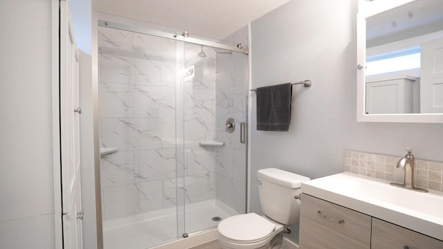 bathroom featuring an enclosed shower, tasteful backsplash, vanity, and toilet