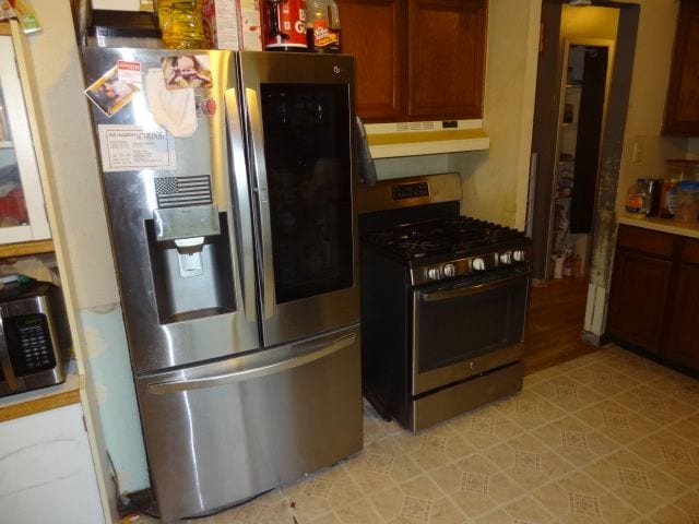 kitchen with stainless steel appliances and range hood