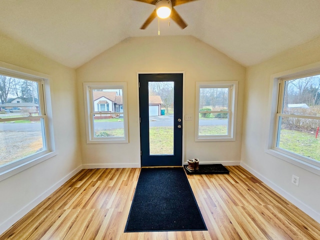 doorway to outside with ceiling fan, light hardwood / wood-style floors, lofted ceiling, and a wealth of natural light