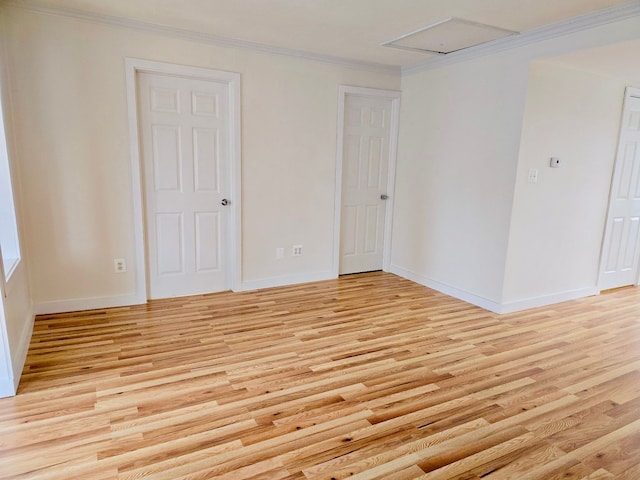 spare room with light hardwood / wood-style floors and crown molding