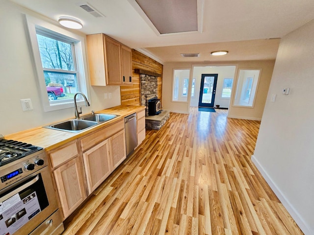 kitchen with light brown cabinets, wooden counters, sink, and stainless steel appliances