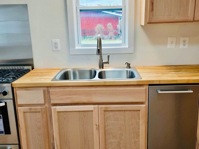 kitchen with light brown cabinetry, sink, appliances with stainless steel finishes, and wooden counters