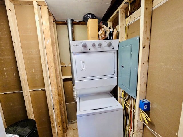 laundry area with electric panel and stacked washer and dryer