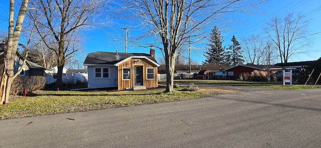 single story home with an outdoor structure and a front lawn