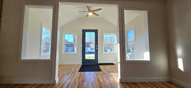 foyer with hardwood / wood-style floors, ceiling fan, and vaulted ceiling