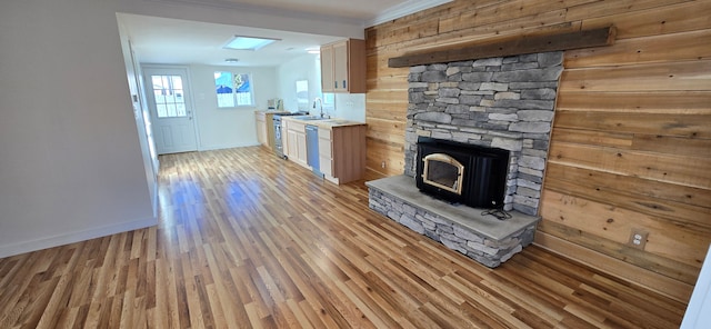 unfurnished living room with light hardwood / wood-style flooring, ornamental molding, and sink