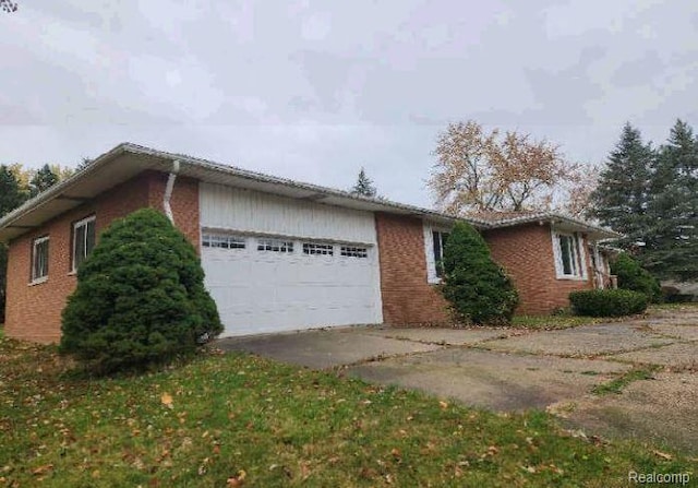 1080 Dye Krest Dr, Flint, MI 48532 - view of side of home featuring a garage, brick siding, and concrete driveway